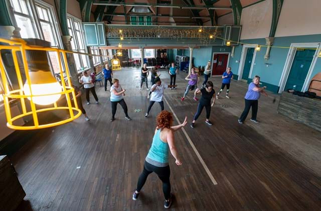 Overhead view of a group dance exercise class in a community centre