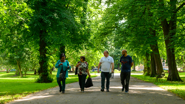 Group of four people walking through a park