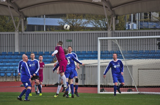 Man jumping over players to head the ball into the goal during a football match