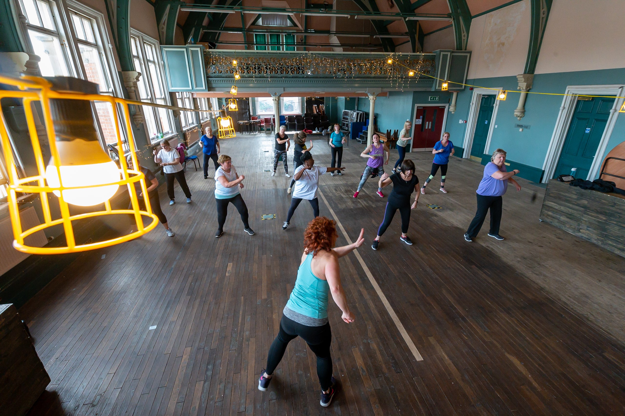 Overhead view of a group dance exercise class in a community centre