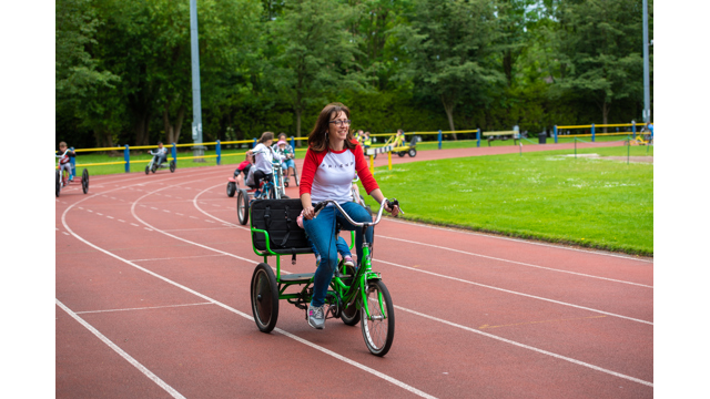 Woman on family bike with child on seat behind