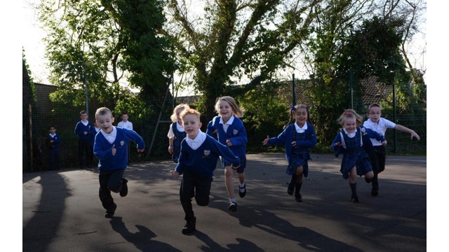 Schoolchildren running around their playground doing The Daily Mile