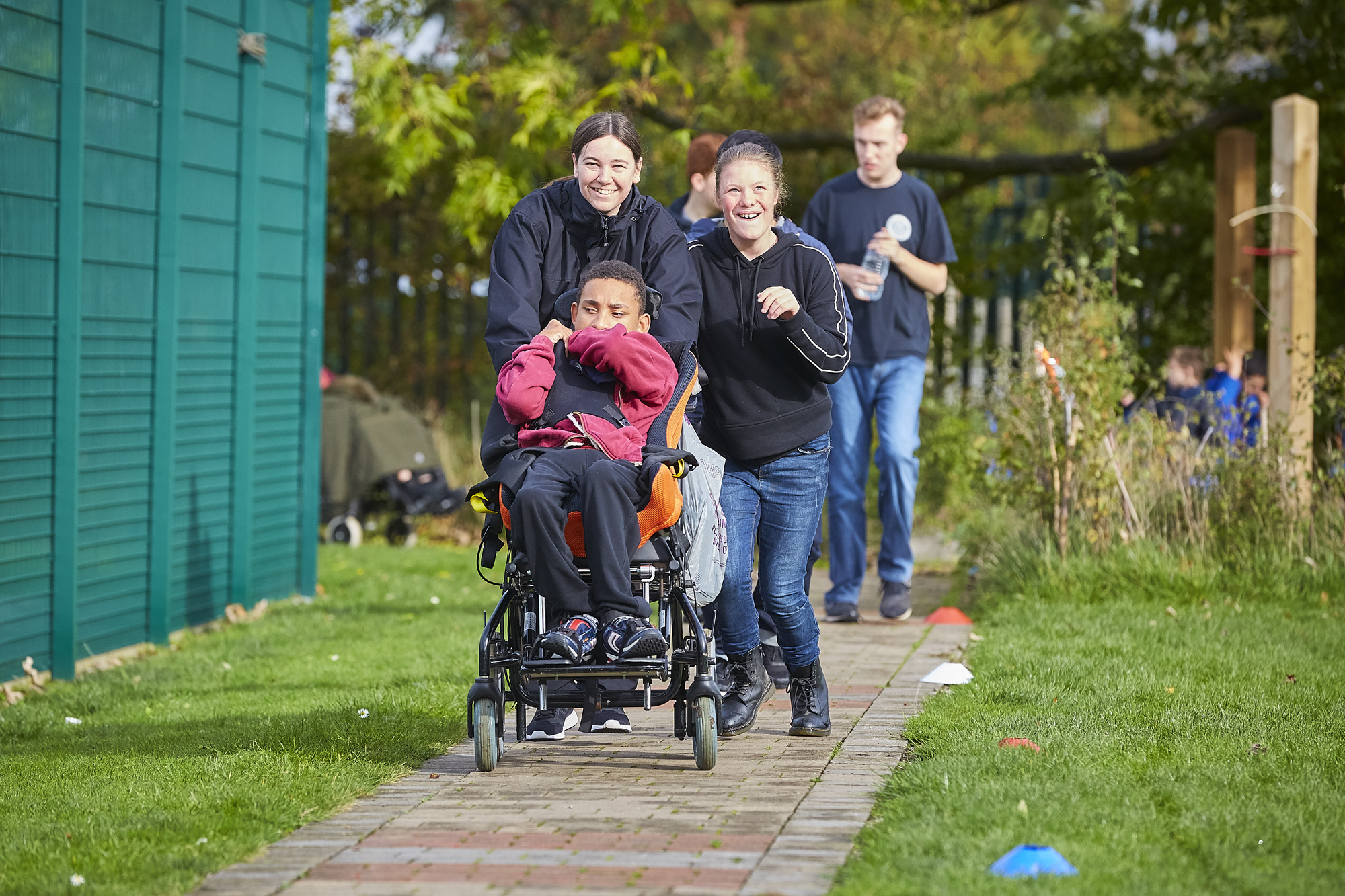 Adults and young people taking part in the daily mile on an outdoor path