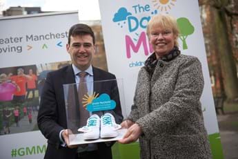 Andy Burnham and Elaine Wyllie holding a pair of Daily Mile branded plimsolls