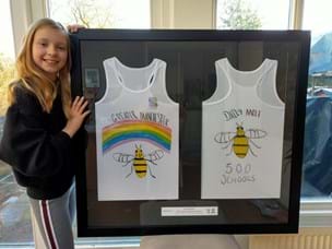 Freya stood next to her framed designed jersey