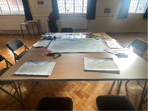 A desk covered in maps and resources for the Right to the Streets place review.